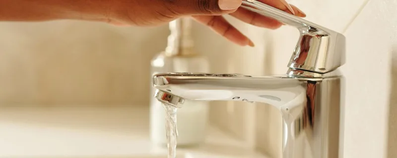 A hand using a modern domestic tap